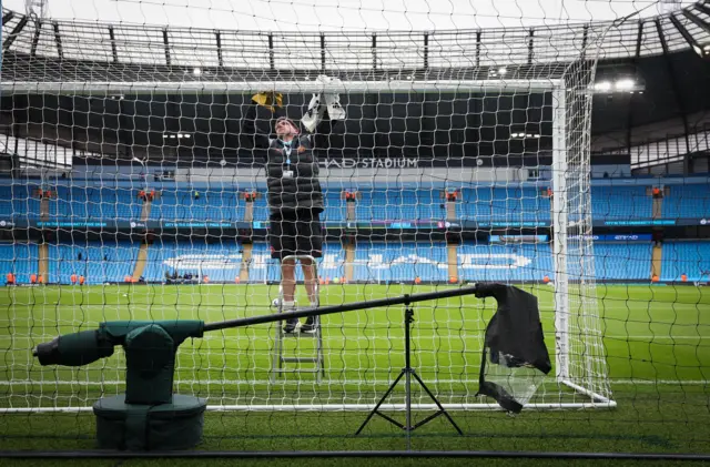 Stadium worker sorts out netting on one of the goals