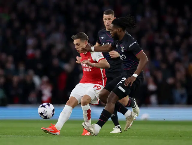 Trossard is chased by two defenders