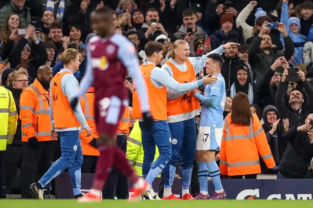 Foden celebrates with subs Haaland, De Bruyne and Stones