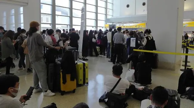 People crowd due to tsunami warning at Naha Airport in Naha, Okinaw