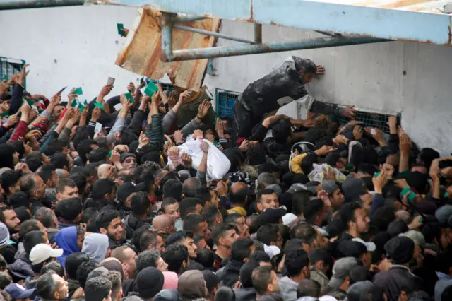 Palestinians gather to receive aid in Gaza City last month