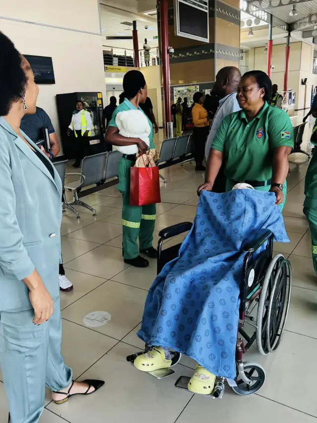 The girl is transported by wheelchair before flying from South Africa to Botswana