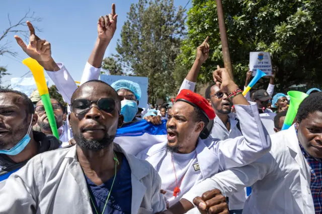 Intern doctors chant as they demonstrate outside the Kenyatta National Hospital to demand better terms including permanent employment in the Kenyan capital, Nairobi on March 22, 2024.