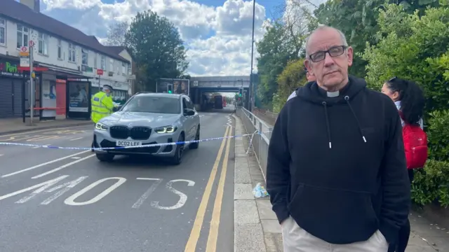 Reverend standing in front of police cordon