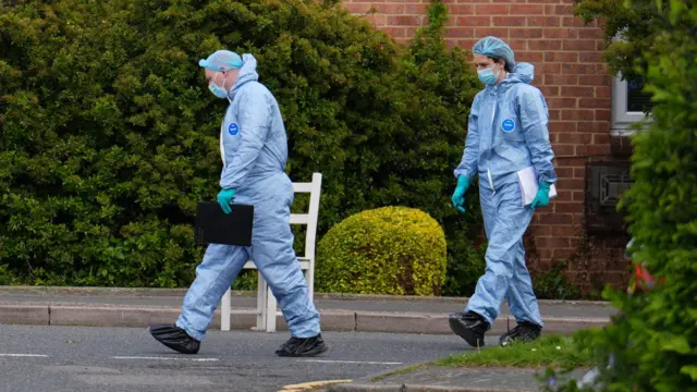 Forensic investigators walking in the crime scene