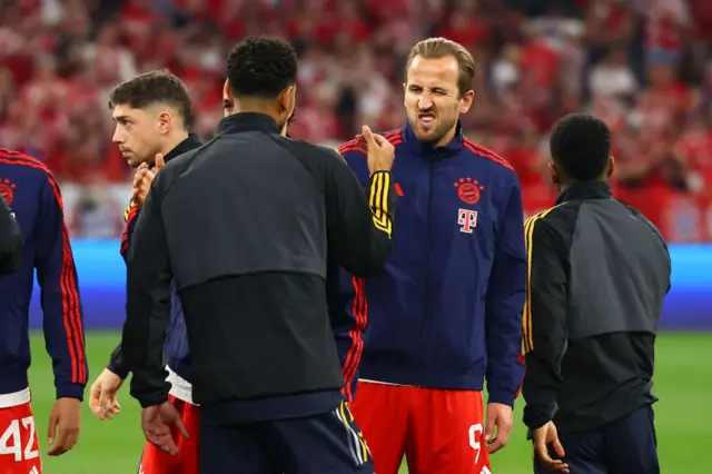 Kane winks as he shakes hands with Bellingham before kick off