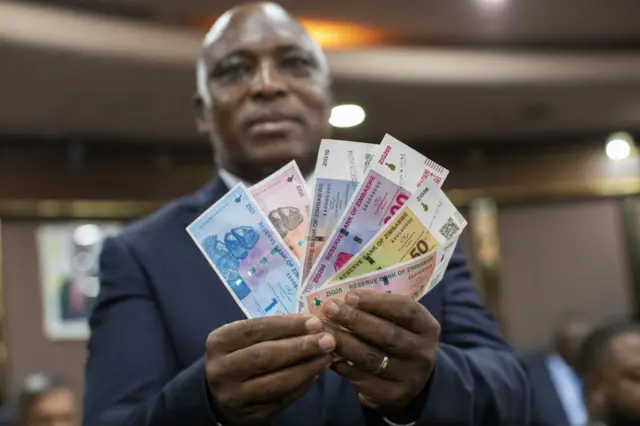 John Mushayavanhu, governor of Zimbabwe's central bank, holds up specimens of a new currency unit called ZiG during a news conference in Harare, Zimbabwe, on Friday, April 5, 2024