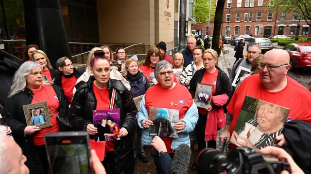 Bereaved families gather outside the Covid-19 inquiry in Belfast