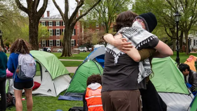 Pro-Palestinian students embrace each other as they take down their encampment after reaching a deal with Brown University