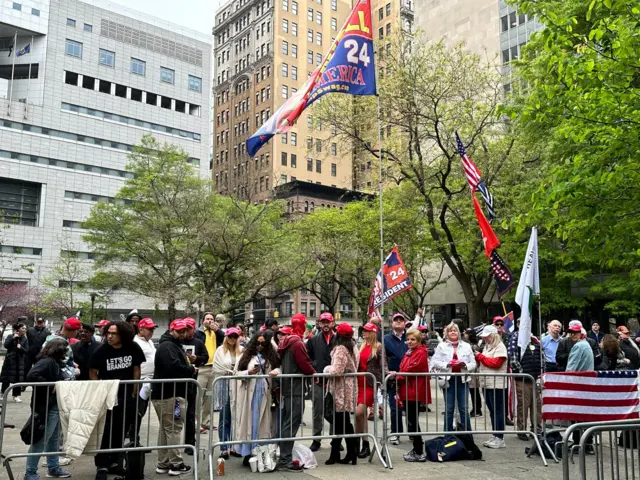 Trump supporters outside court with Maga hats and flags