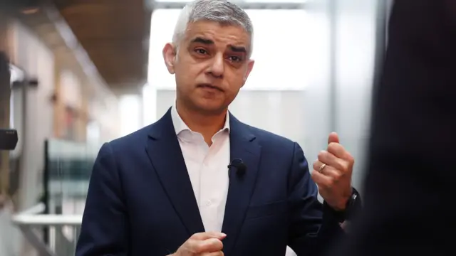 Mayor of London Sadiq Khan gestures while speaking to a reporter