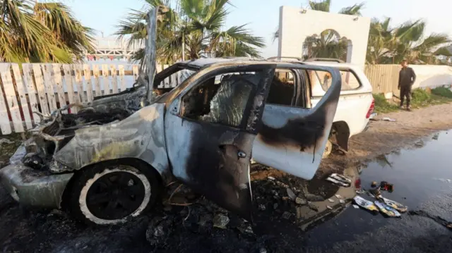 A person looks at a vehicle where employees from the World Central Kitchen (WCK), including foreigners, were killed in an Israeli airstrike, according to the NGO as the Israeli military said it was conducting a thorough review at the highest levels to understand the circumstances of this "tragic" incident, amid the ongoing conflict between Israel and Hamas, in Deir Al-Balah