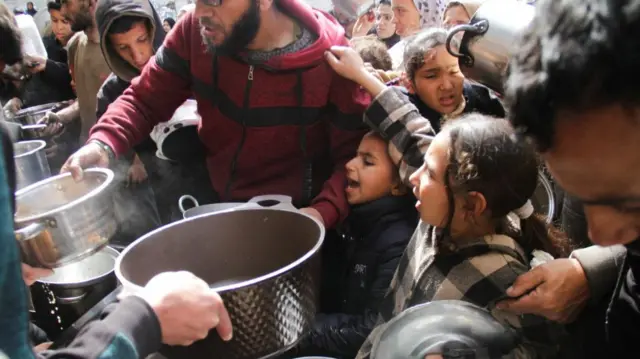 Palestinians gather to receive free food (file photo from March 2024)