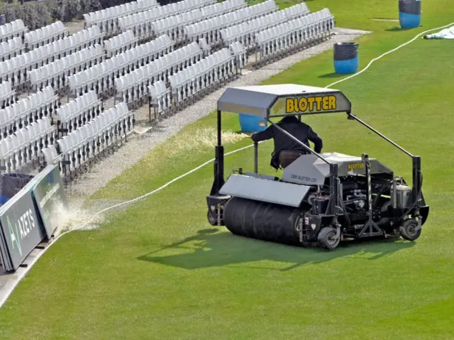 Kent groundstaff clear water from the Canterbury outfield