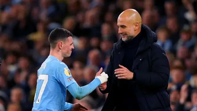 Phil Foden shakes hands with Manchester City manager Pep Guardiola