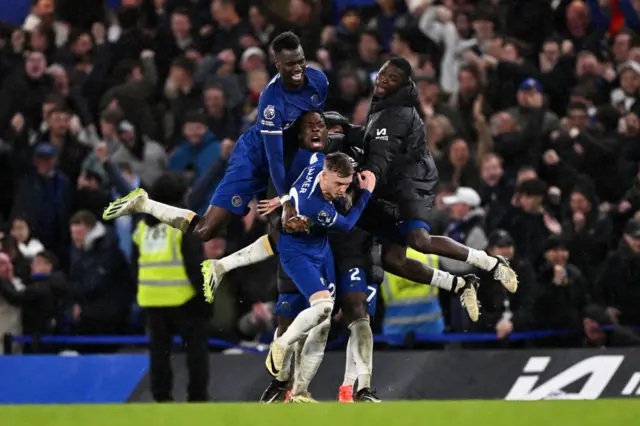 Chelsea players celebrate with Cole Palmer