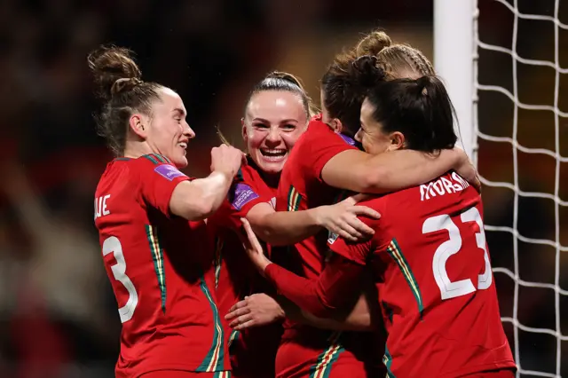 Angharad James of Wales (hidden) celebrates scoring her team's fourth goal with teammates during the UEFA EURO 2025 Women's Qualifiers match between Wales and Croatia at Racecourse Ground on April 05, 2024 in Wrexham