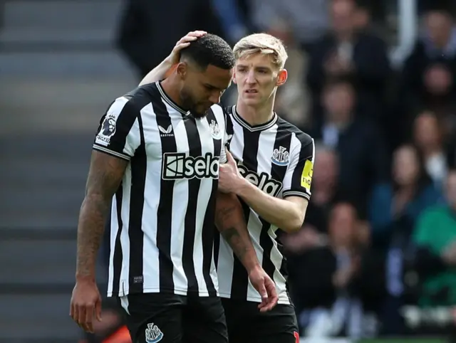 Newcastle's Jamaal Lascelles is consoled by Anthony Gordon as he comes off injured against West Ham