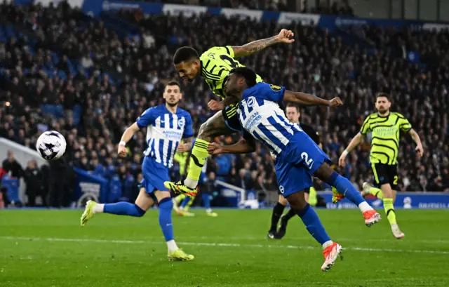 Jesus rises above Lamptey to head towards goal