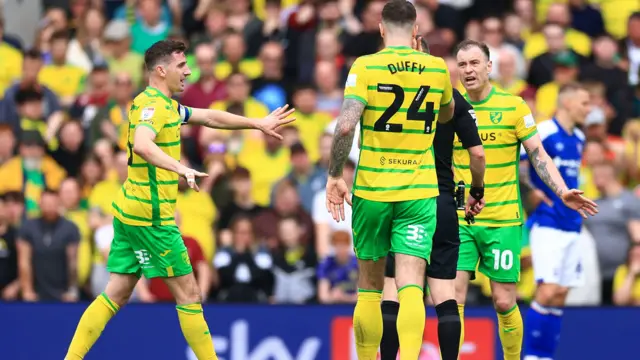 Norwich players protest with referee