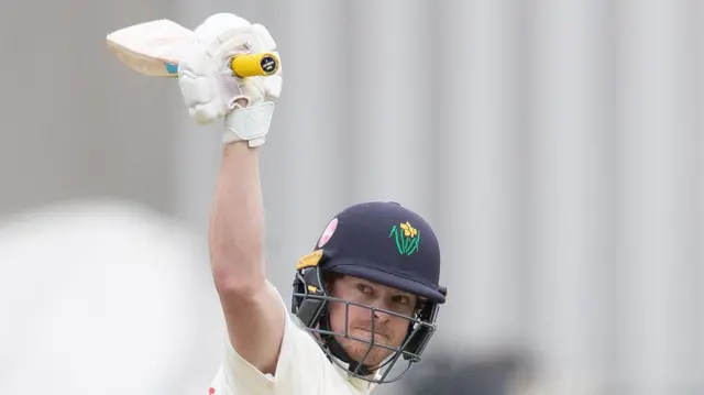 Sam Northeast raises his bat for reaching 200