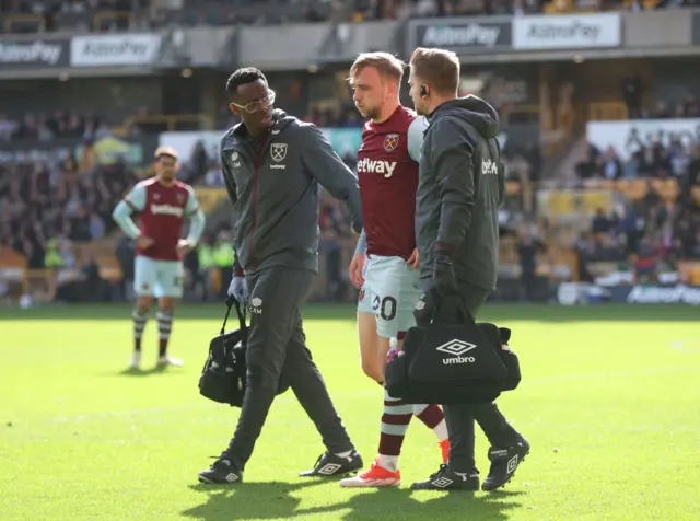 Bowen is helped off the pitch by two physios