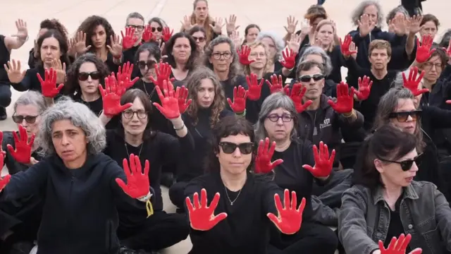 Protestors in Tel Aviv with red painted hands