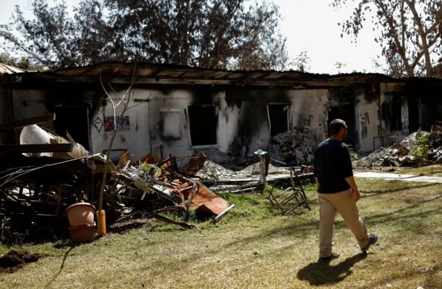 A resident of kibbutz Nir Oz walks in front of houses that were burnt during the deadly 7 October attack on Israel, 12 March 2024