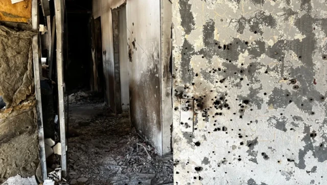 Bullet holes are pictured in the walls of a burnt out building in kibbutz Be'eri