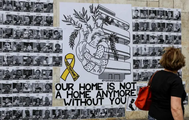 A woman looks at a wall of posters with pictures of hostages kidnapped in the deadly October 7 attack on Israel by the Palestinian Islamist group Hamas from Gaza, in Tel Aviv, Israel, April 7, 2024.