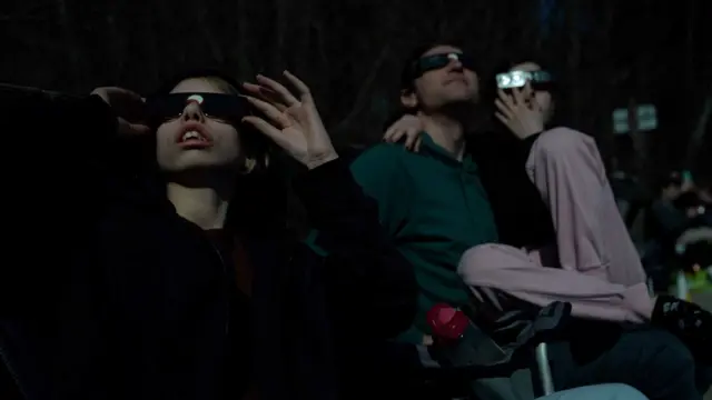 Spectators in the dark watching the eclipse