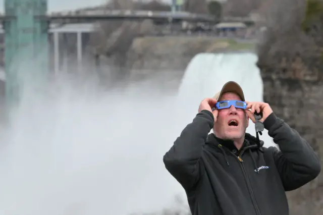 A man watches the approaching eclipse in Niagara Falls, New York