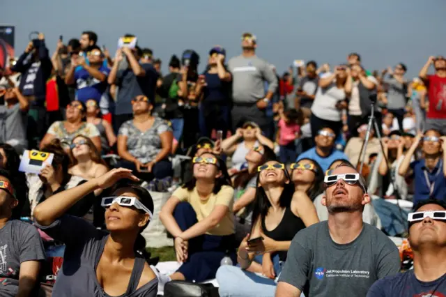 People wear glasses to view an eclipse