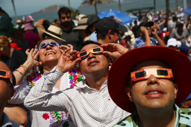 People use protective eyewear to observe a total solar eclipse in Mazatlan, Mexico