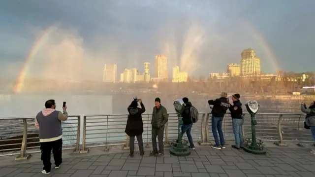 People at Niagara Falls State Park watch Niagara Falls and the rainbow ahead of a solar eclipse to take place later in the day, in New York, U.S., April 8, 2024.