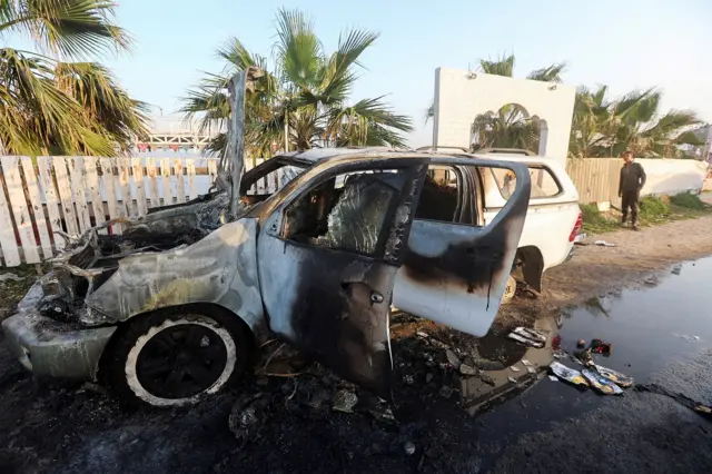 An image showing a person looking at a vehicle where employees from World Central Kitchen were killed in an Israeli airstrike