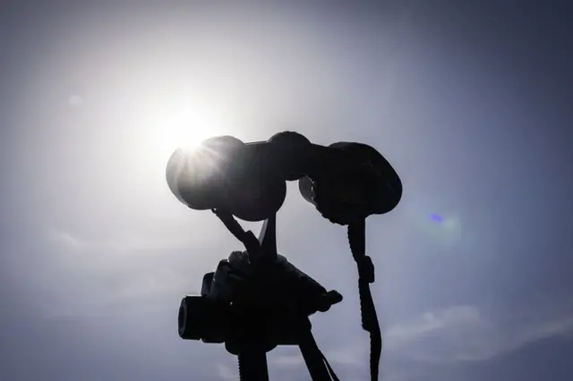 A pair of binoculars aimed at the sun