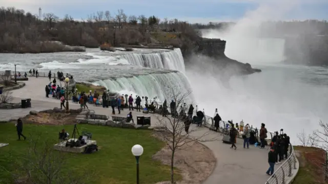 People gather at Niagara Falls State Park ahead of a total solar eclipse across North America, in Niagara Falls, New York, on April 8, 2024