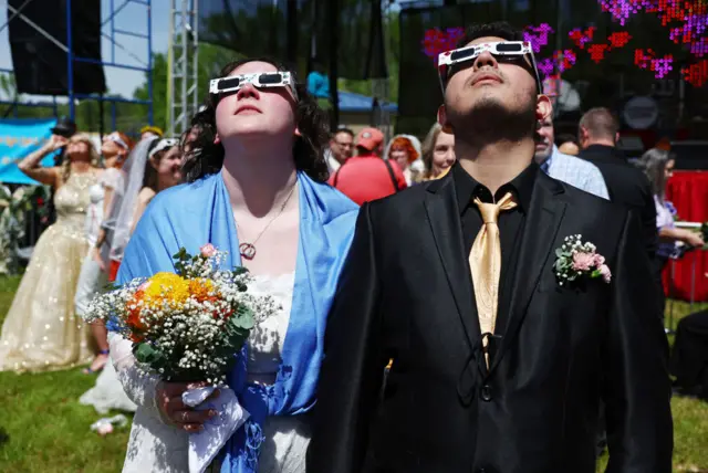 A couple stands looking at the eclipse