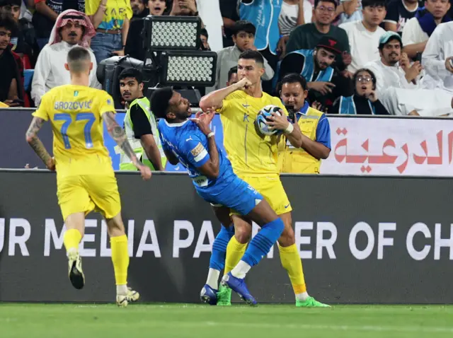 Cristiano Ronaldo elbows an opposition player during Al-Nassr v Al-Hilal