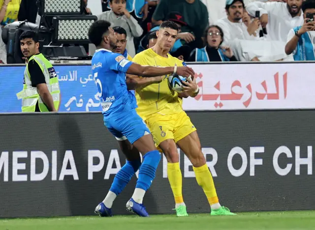 Cristiano Ronaldo elbows an opposition player during Al-Nassr v Al-Hilal