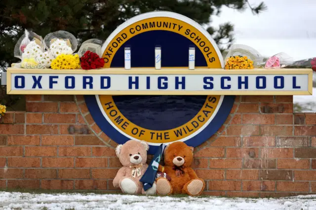 Stuffed bears and flowers are gathered at a makeshift memorial outside of Oxford High School on December 01, 2021 in Oxford, Michigan.
