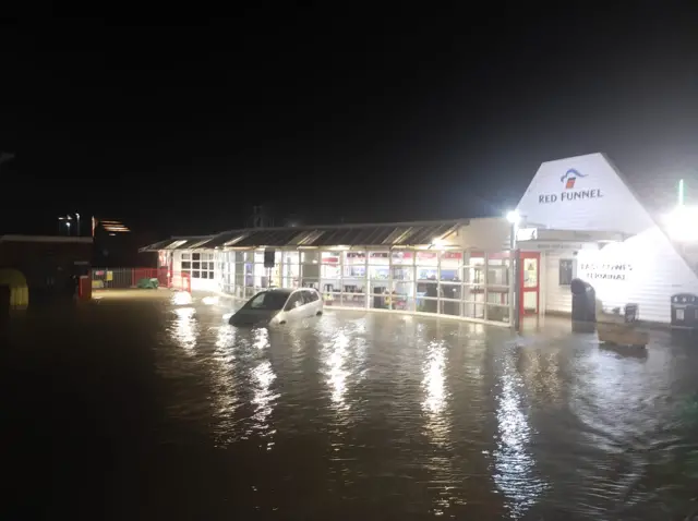 Car in flood water outside ferry terminal