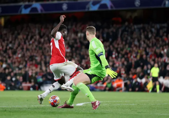 Saka kicks Neuer's leg as he comes out of his net to close him down