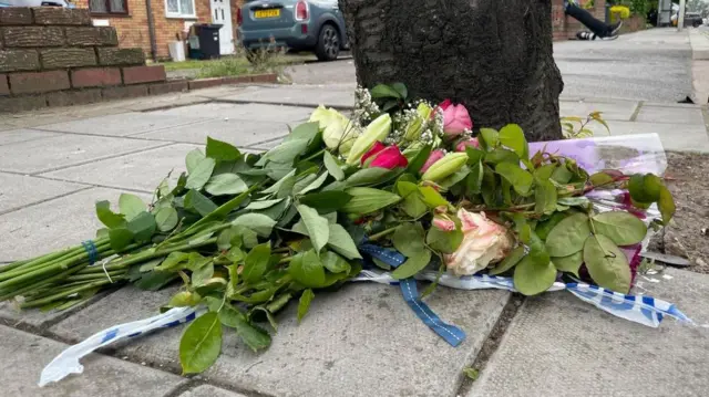 Floral tributes left near the police cordon in Hainault, north east London, where a 14-year-old boy was killed in a sword attack on Tuesday, that saw four others injured, including two Metropolitan Police officers.