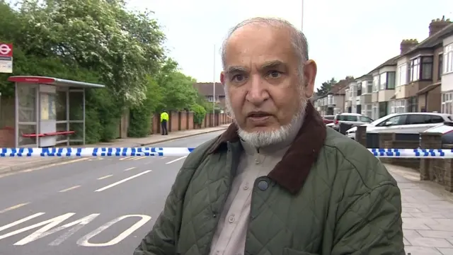 Sikandar Uddin speaking near the police cordon