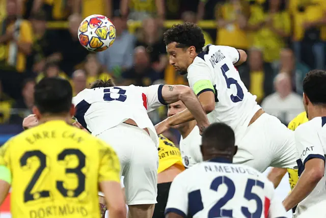 Marquinhos (R) heads the ball