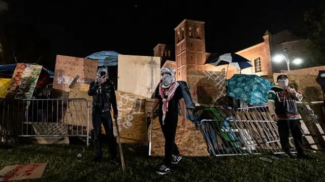 Pro-Palestinian demonstrators stand near a makeshift barricade