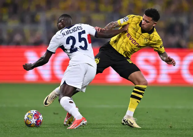 Nuno Mendes of Paris Saint-Germain is challenged by Jadon Sancho