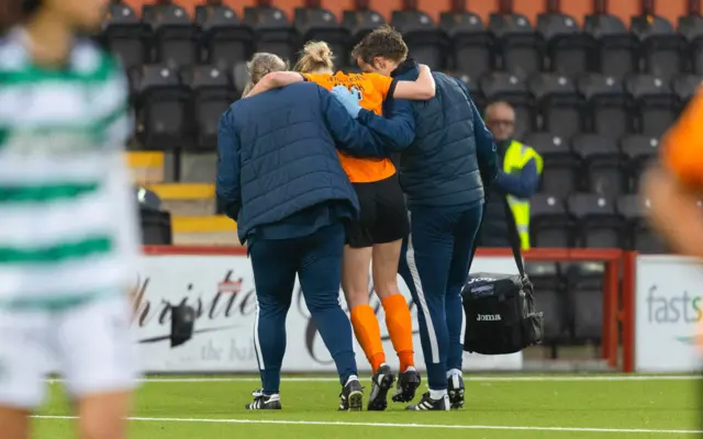 Claire Walsh being helped off the pitch